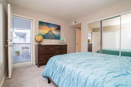 丹纳岬Beach Condo的一间卧室设有蓝色的床和窗户。