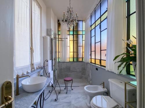 都灵L'Angolo di Casa Verrua的浴室设有2个水槽、2个卫生间和1个吊灯。