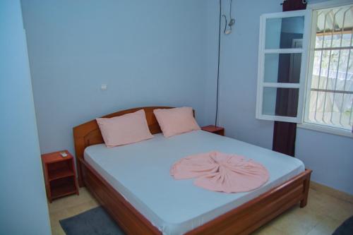 黑角studio brasserie的一间小卧室,配有一张带粉红色枕头的床