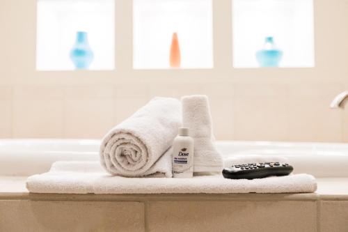 Spring CityGrand Hotel的浴室提供毛巾和浴缸遥控器