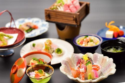 鸟取市卡苏特考泽尼亚日式旅馆的餐桌,盘子上放着食物和碗