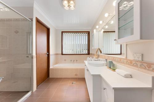 蚬壳港Shell Cove Coastal Haven的白色的浴室设有浴缸和水槽。
