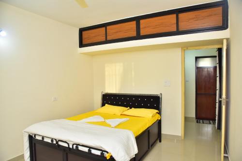 TalaulimFieldstone Lovely 2 BHK AC Apartment的一间卧室配有一张带黄色床单的大床
