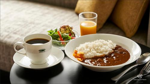 大阪Daiwa Roynet Hotel Osaka Sakaisuji Honmachi PREMIER的饭碗和咖啡的桌子