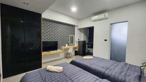 北榄府Irich Residence สาขา สำโรงใต้的一间卧室配有两张床和电视。