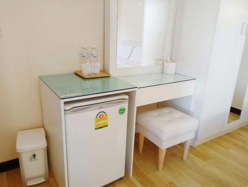 Ban Don Klangโรงแรมเรือนไทย 1 (Thai Guest House)的一张带镜子的白色小书桌和一台小冰箱