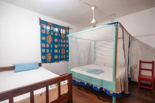 江比阿Kiungani Lodge的一间卧室设有两张床和天篷