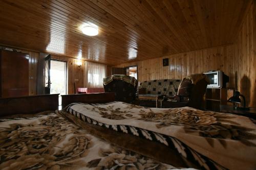 茨卡尔图博Nika house的木墙客房内的一张大床