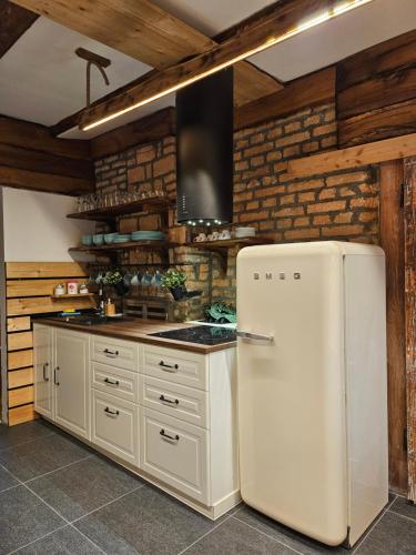 卡姆尼克Hiša stare mame的厨房配有白色冰箱,设有木墙