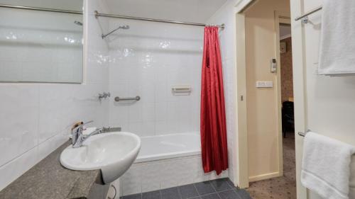 蒂默特Ashton Motel的浴室配有盥洗盆和浴缸。