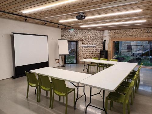 La Côte-Saint-AndréLa ferme de Berlioz的一间会议室,配有白色的桌子和绿色的椅子