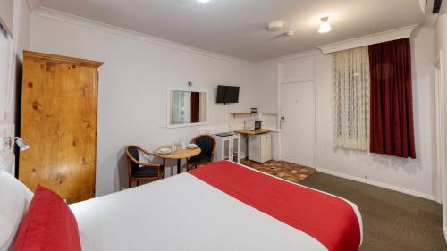 蒂默特Ashton Motel的酒店客房配有一张床铺、一张桌子和一张书桌。