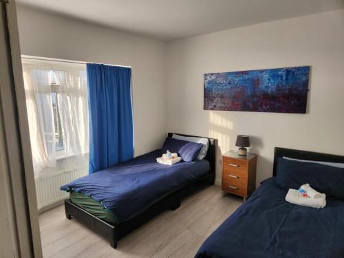 GoodmayesLovely private bedroom in a 5-bedroom home in Dagenham London with a lounge的一间卧室设有两张床和窗户。