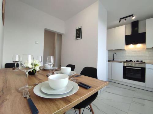 雷布尼克***Santorini Apartament*** - 40m² ✓的厨房配有木桌、盘子和酒杯