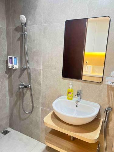 巴淡岛中心Wawa Guesthouse Pollux Habibie Batam Tower A 18的浴室配有盥洗盆和带镜子的淋浴