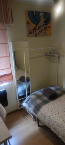 马德里Habitacion individual en apartamento céntrico的一间卧室配有两张双层床和镜子