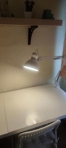 马德里Habitacion individual en apartamento céntrico的白色桌子上架子上的灯