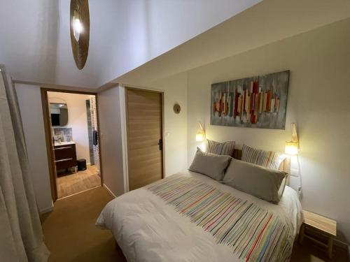 AndéAu bal des hirondelles的卧室配有一张带两个枕头的大白色床
