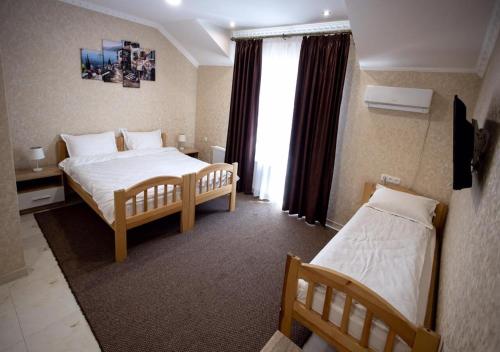 乌曼岛Готель River House的酒店客房设有两张床和窗户。