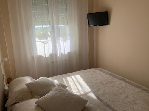 阿拉西奥Ca Bea的一间卧室配有带两个枕头的床和窗户