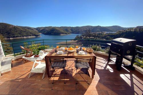 费雷拉杜泽济里Blue Lake House的阳台设有烧烤架和桌子,享有风景。
