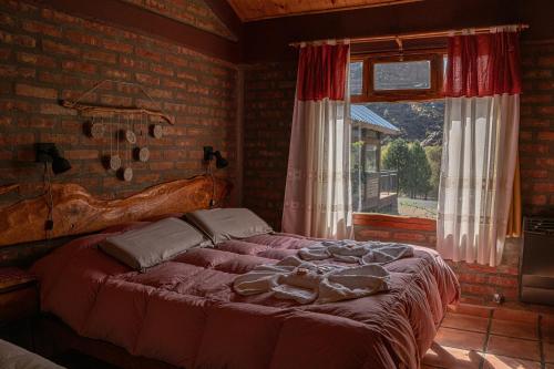 阿卢米内El Hostal del Rio的卧室在窗户前配有一张大床