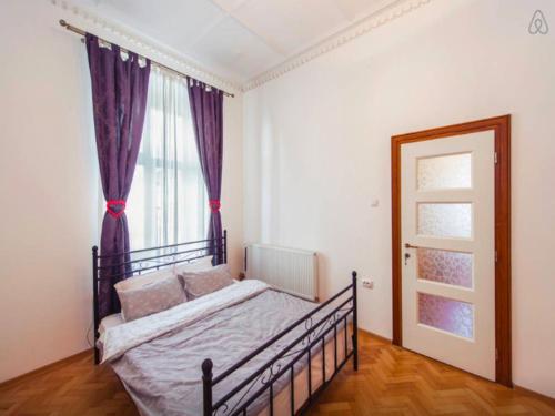 布拉索夫Love Nest的一间卧室配有一张带紫色窗帘的床和窗户。