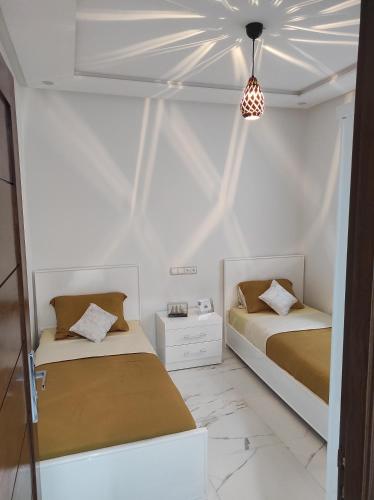 纳祖尔La Joie Al Jadid的白色墙壁客房的两张床