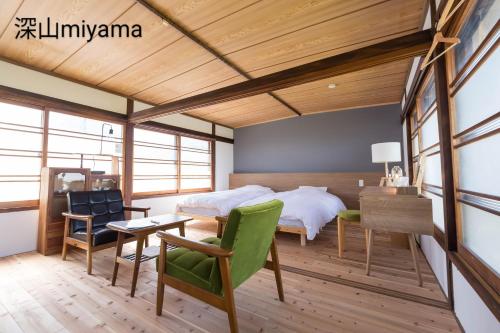 Zentsuji深山邸miyama-tei的卧室配有一张床、一张桌子和椅子