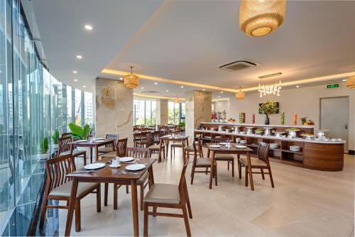 岘港Capecia Danang Hotel and Apartment的一间带木桌椅的餐厅和一间酒吧