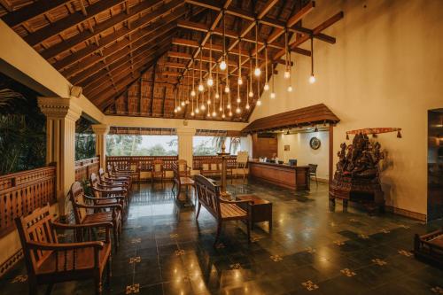 特里凡得琅Aadisaktthi Leisure Resort, Kovalam的用餐室配有木桌和椅子