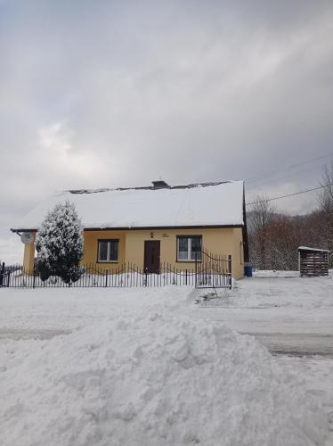 Nowa WieśSielankowy Domek的一座黄色房子,屋顶雪盖