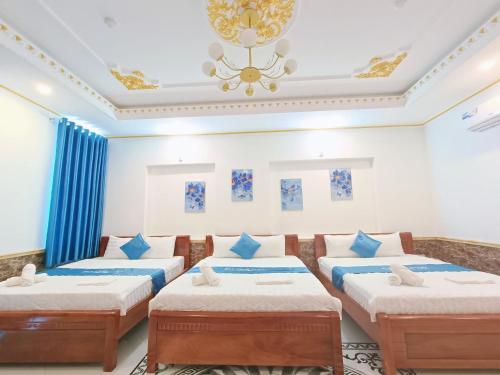 芹苴Phuong Thuy Hotel的一间设有四张床和吊灯的客房