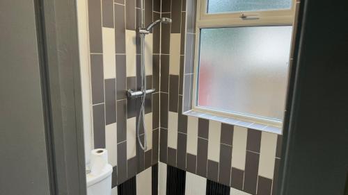 BloxwichOne Bedroom Apartment in Walsall Sleeps 4 FREE WIFI By Villazu的带淋浴、窗户和卫生间的浴室