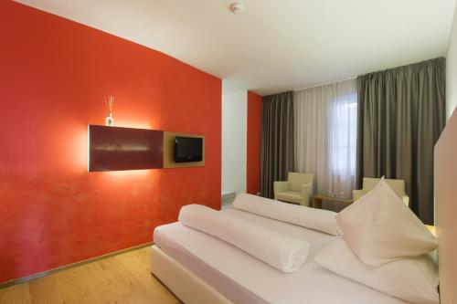 卡尔达罗戈登内尔斯特恩酒店的酒店客房带白色的沙发以及红色的墙壁