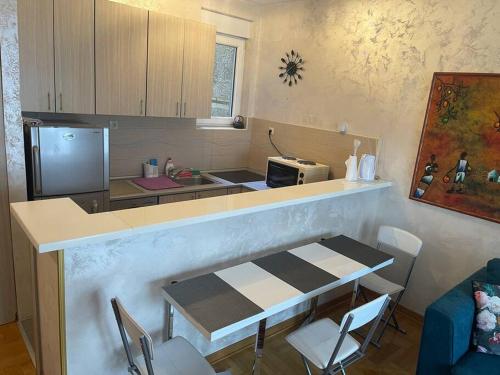 弗拉查尔（历史区）Art-Inspired, Cozy Apartment的厨房配有柜台、桌子和微波炉