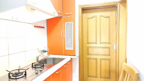 上海Lily's home的厨房设有橙色门和水槽