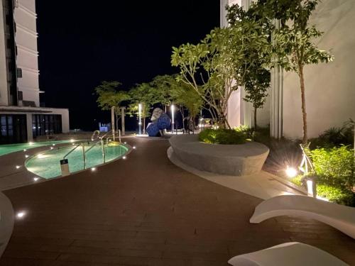 哥打京那巴鲁Sunset Seaview Studio Apartment at Kota Kinabalu City Centre的庭院,晚上设有游泳池
