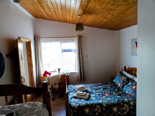 威克洛Sunriseview Cottages的一间卧室配有一张床、一张桌子和一个窗户。