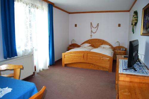 Dorfstetten安革若夫酒店的一间卧室配有木床和电视