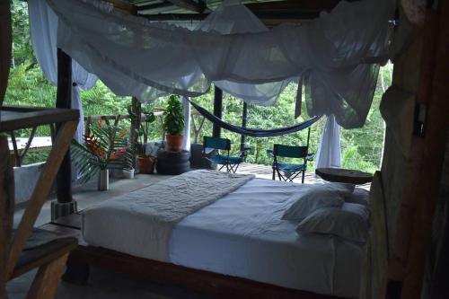 比利亚加松Portal del Sol的一间卧室配有一张天蓬床和两把椅子