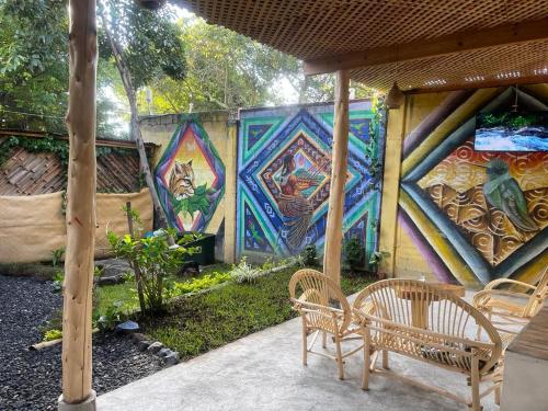 SololáCasa Josep H'i的庭院设有两把椅子和一堵涂鸦墙