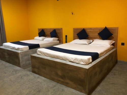 拉特纳普勒Palabaddala Tea and Eco Lodge的配有两张大床的黄色墙壁客房