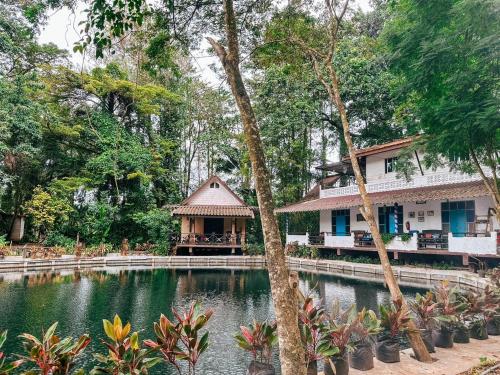 Ao LukBaan Suanthip Homestay - Aoluek Natural Retreat的一座带池塘的度假村,位于一座房子前面