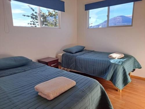 科伊艾科Cómodo departamento full equipado en Coyhaique的带2扇窗户的客房内的2张床