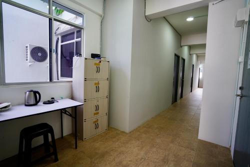 古晋Swanling Kuching的客房设有书桌、冰箱和走廊。