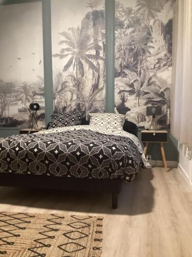 圣若瑟Le Niaouli的一间卧室配有一张床和棕榈树壁画