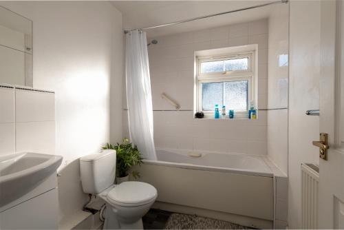 吉林汉姆Cosy Retreat - SmartTV and Wi-Fi的白色的浴室设有卫生间、浴缸和水槽。