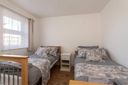 吉林汉姆Cosy Retreat - SmartTV and Wi-Fi的一间卧室设有两张床和窗户。