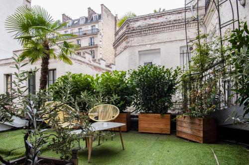 巴黎巴蒂诺勒酒店的一个带植物和桌椅的庭院